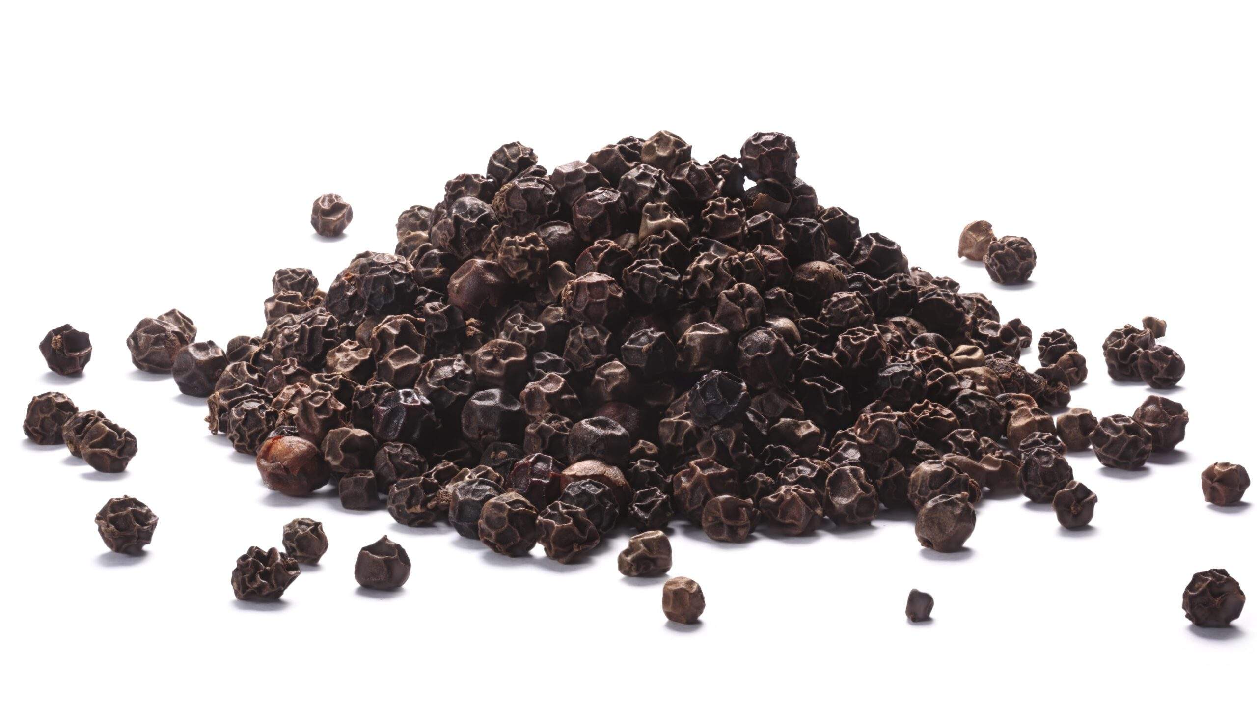 Pile of black peppercorns (dried seeds of Piper nigrum). Clipping paths, shadows separated